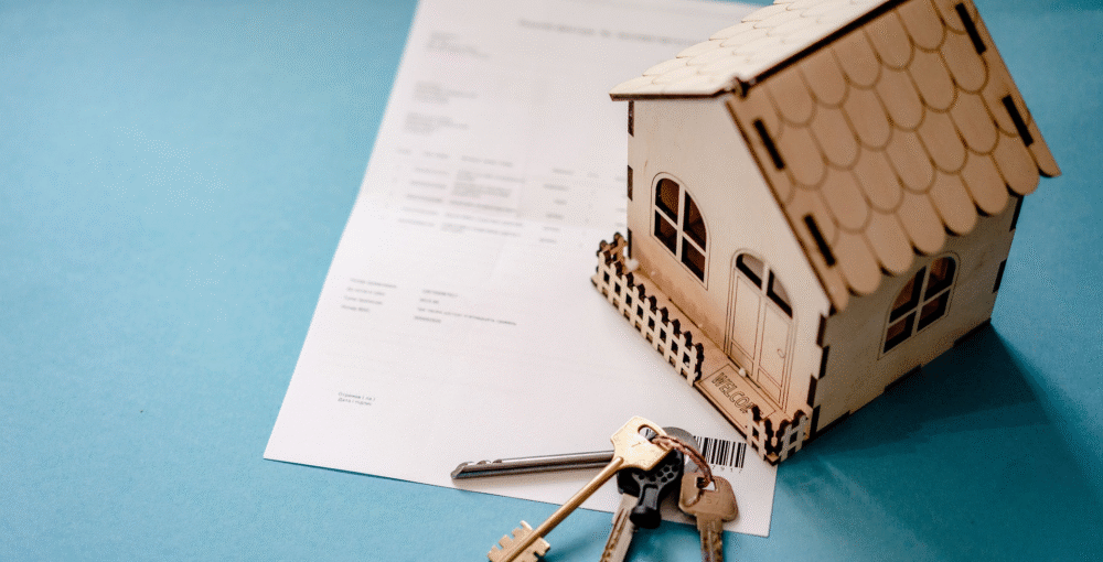 House model, property documents and keys representing property ownership, TOLATA claims and cohabitation disputes.