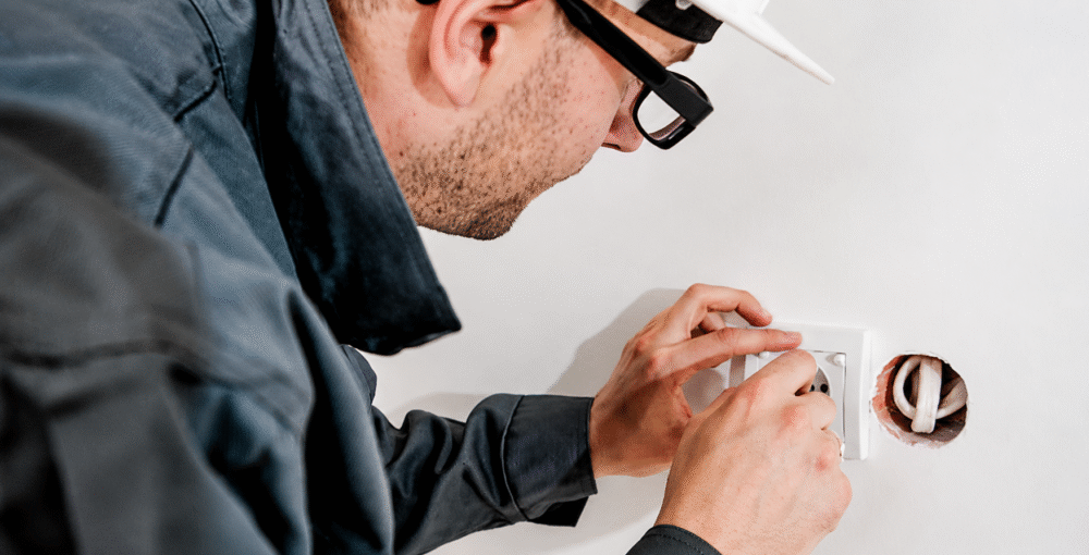 Electrician carrying out electrical work at a residential property, illustrating home improvements and property ownership disputes.