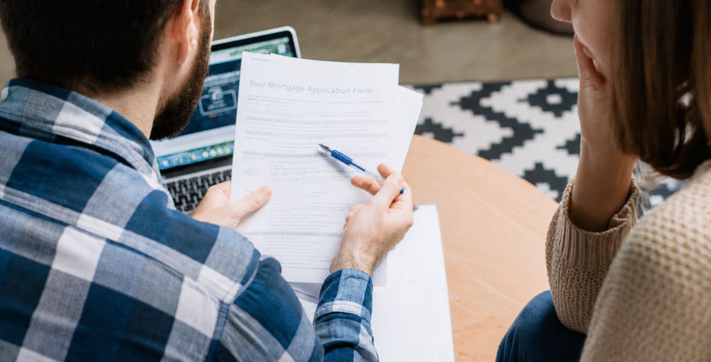 Couple reviewing mortgage and property ownership documents during a serious discussion about a property dispute and legal advice.