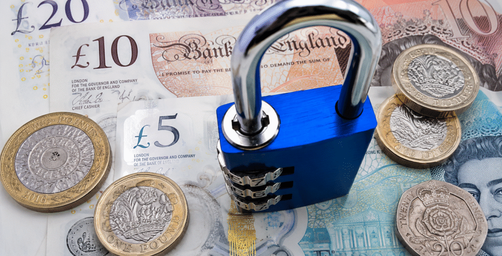 Blue combination padlock securing British pound banknotes and coins, representing financial security, asset protection and legal planning